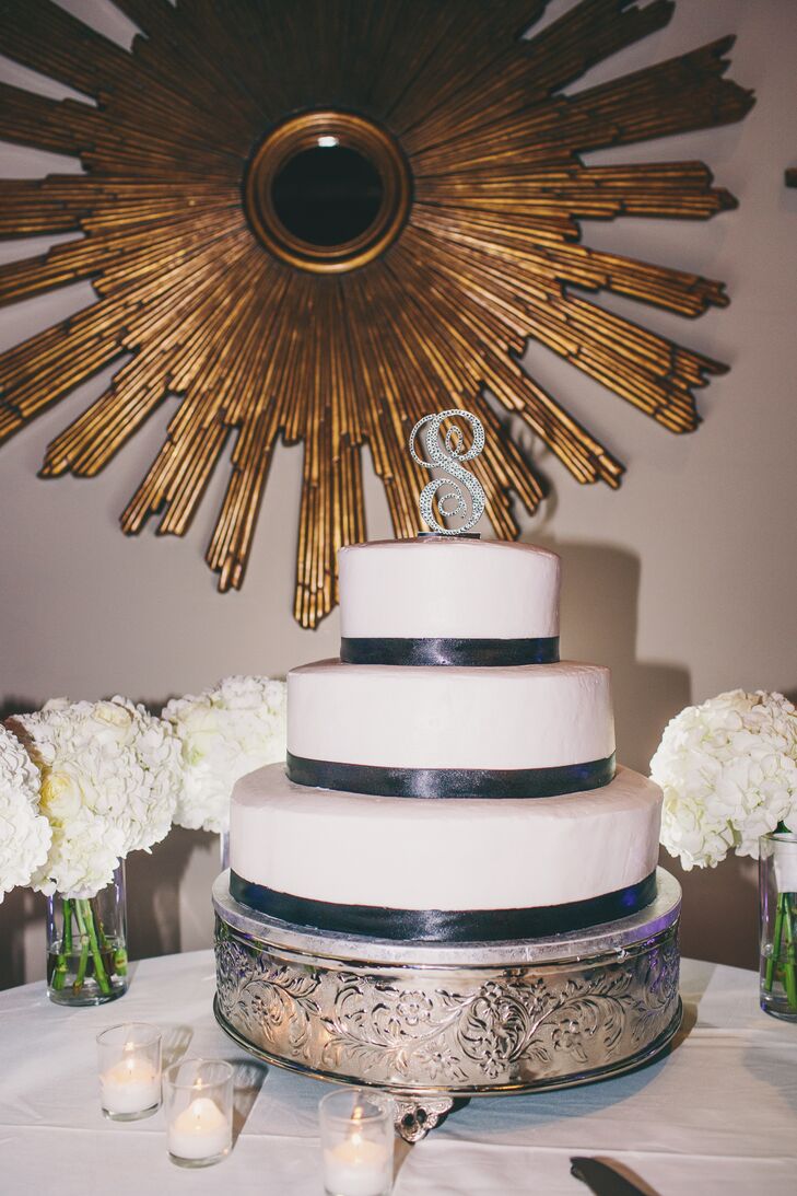 Christina and Neil kept their color palette in mind when they chose to serve a simple yet stunning three-tier white wedding cake with gray accents and a sparkly monogrammed cake topper.