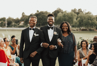 Groom and groom's parents walking down the aisle