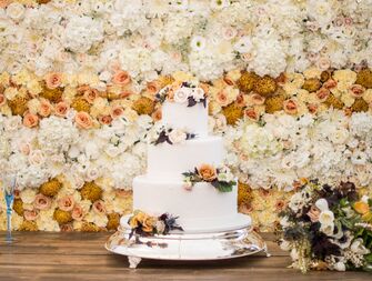 three-tier fall wedding cake decorated with hand-piped polka dots and fresh flowers