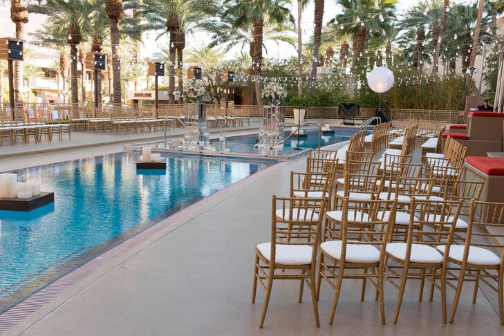 Gold chiavari chairs were placed next to the pool, where a clear platform was set up over it. The same chairs were later used as seating for the dinner with the tables placed around the pool.