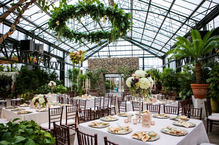 With linen tablecloths, brown chiavari chairs, tall floral arrangements and lush greenery, the overall vibe of the reception was that of a sophisticated garden party. The glass ceiling—showcasing the sky—added to the feeling of being outdoors.
