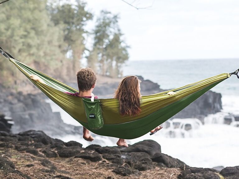 Couple relaxes on an outdoor hammock. 