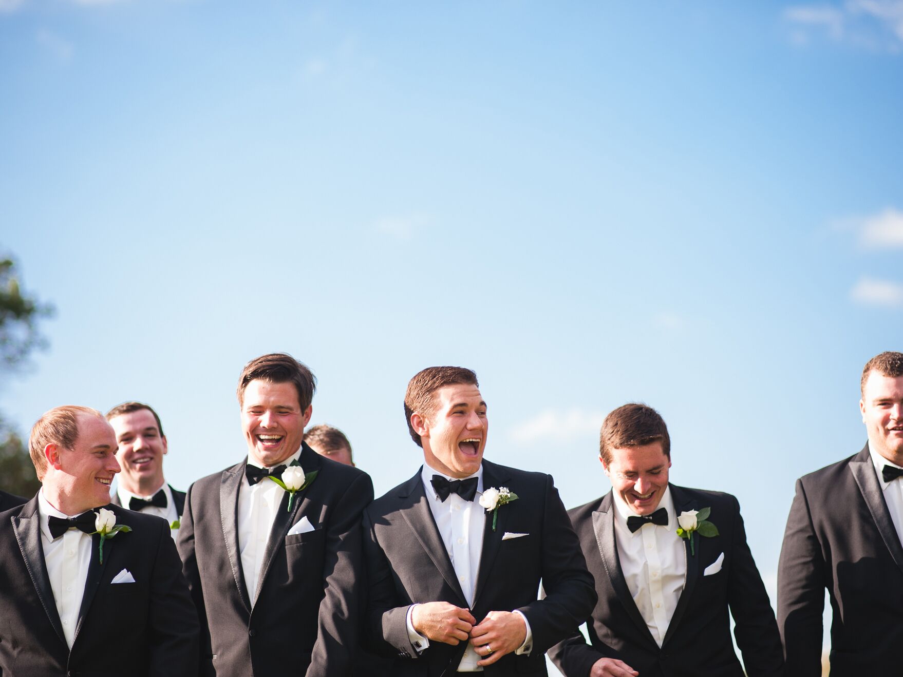 Groom and groomsmen celebrating outside