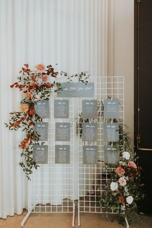 Seating Chart on Grid Display With Earth-Tone Flowers at a Fall Wedding