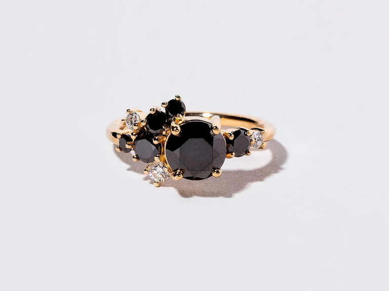 Black diamonds cluster like ripe grapes in the sun on this stunner of an engagement ring.
