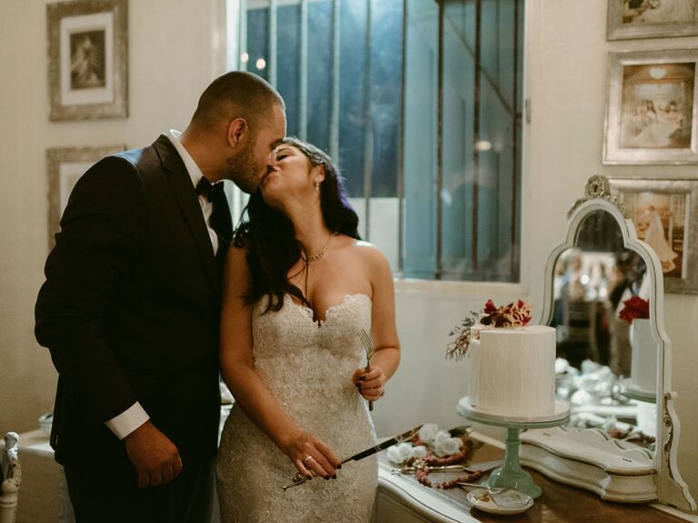 Bride and groom cutting cake at wedding reception