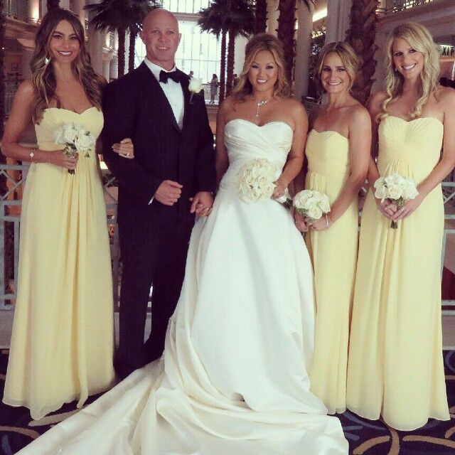 Sofia Vergara and bridesmaids wear pale yellow gowns and pose with the bride. 