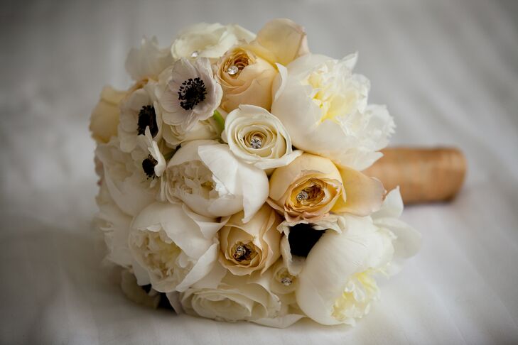 Marielle's bouquet was filled with ivory peonies, garden roses, ranunculuses and anemones, as well as nude-colored roses for a romantic, vintage-inspired feel. Crystal accents added a subtle touch of glitz to the bouquet.