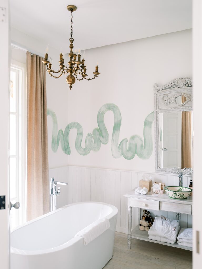 Bathroom with tub and ornate chandelier at Villa Bokeh in Antigua, Guatemala