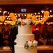 Pam and Caleb had a four-tier ivory cake covered in lined buttercream. A greenery wreath surrounded the confection, and orange and white flowers and yellow hypericum berries added touches of fall hues.