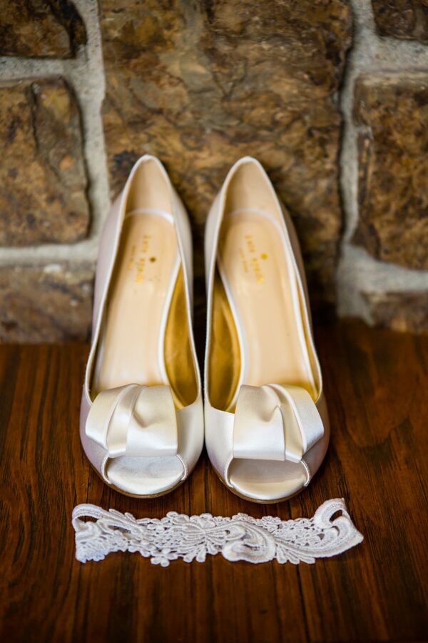 Michelle picked out a pair of ivory silk Kate Spade shoes with a peep toe and gorgeous ribbon design on top. Her white lace garter laid in front of the shoes, both going along with her white Monique Lhuillier dress.