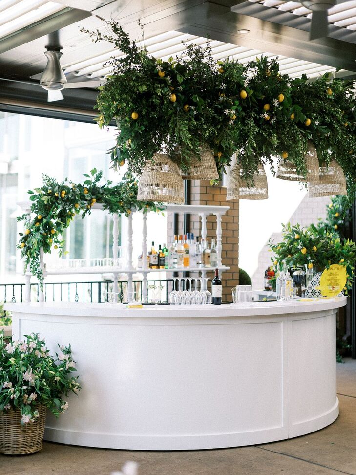 White Rehearsal Dinner Bar With Hanging Lemons, Greenery and Rattan Chandeliers