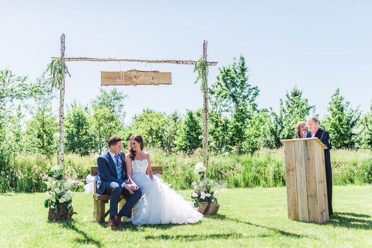 During the ceremony, Amanda and Jan sat on a wooden bench out of an arch made of birch wood. The arch was decorated with greenery and featured a sign with the couple's initials.