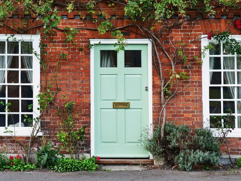 teal front door on brick house