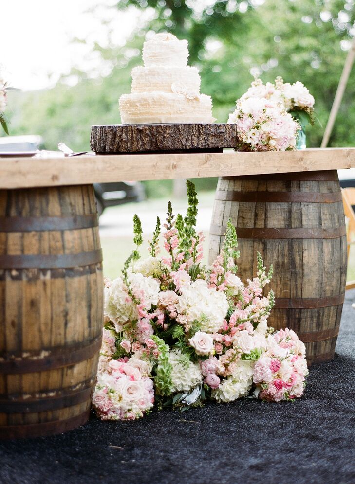 The newlyweds showed off their three-tier cake on a table made from vintage barrels.
