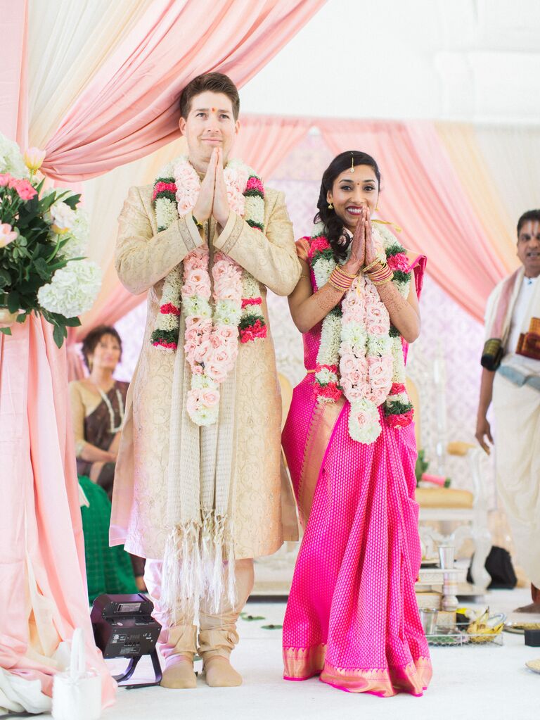 Bride wearing a unique bright pink and gold saree. 