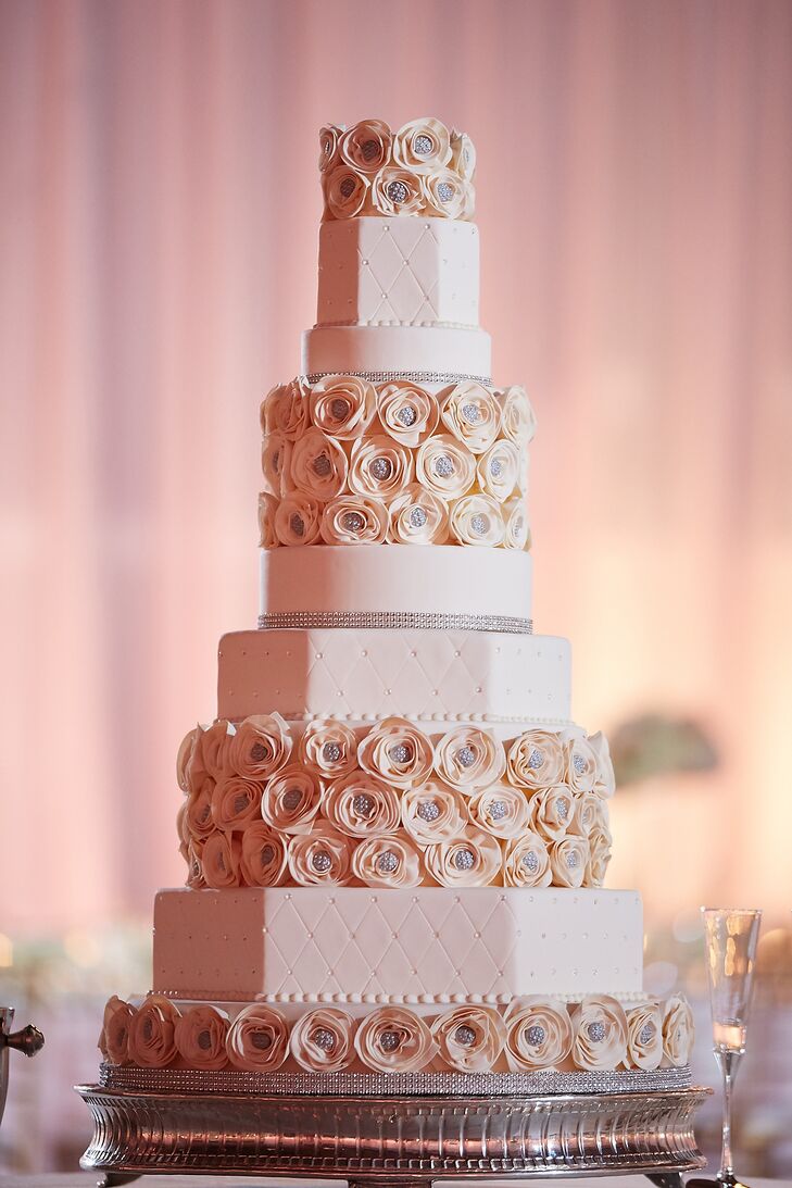 Maria and Chris enjoyed a nine-tier geometric ivory wedding cake for dessert. Three layers were adorned with geometric diamond patterns and crystals, two layers were round with crystal detailing on the bottom, and four layers were decorated with cream and crystal rosettes.