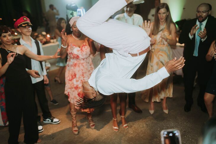 Guest Doing a Standing Flip on the Dance Floor With Guests Around Him