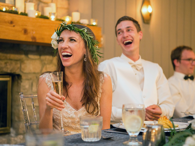 Bride and groom at reception watching wedding slideshow