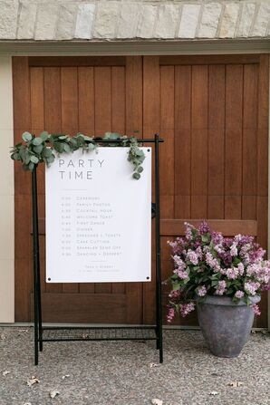 Wedding Program Sign Decorated With Silver Dollar Eucalyptus Beside Lilac Bush