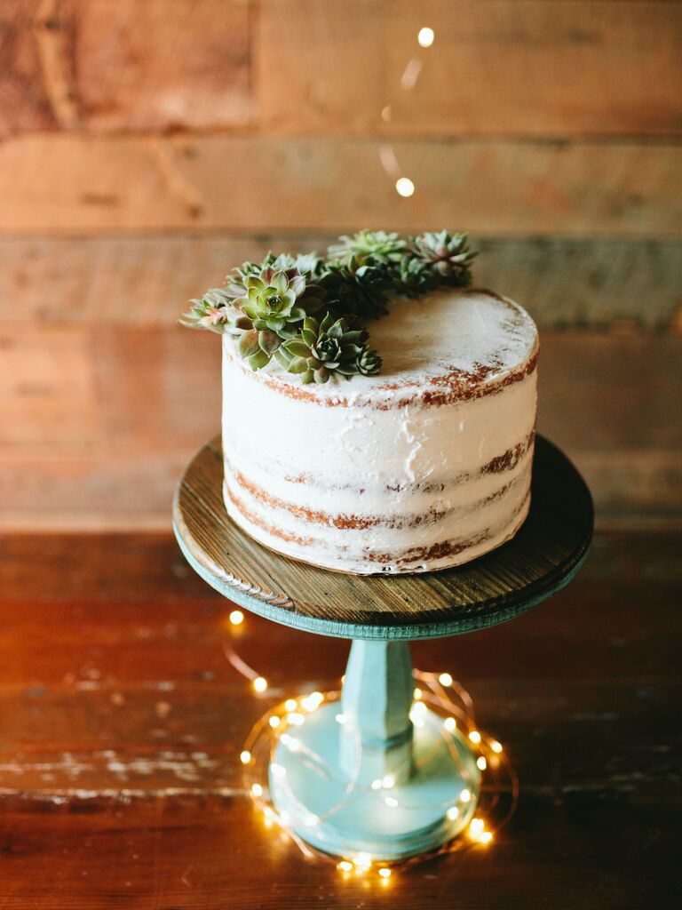 simple rustic one tier wedding cake with semi naked frosting and succulents