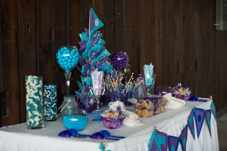 Blue, white and purple candies were displayed in clear jars for a sweet treat dessert table.