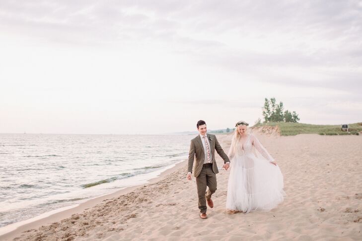 Couple Holding Hands and Walking Along Beach at Lake Michigan