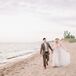 Couple Holding Hands and Walking Along Beach at Lake Michigan