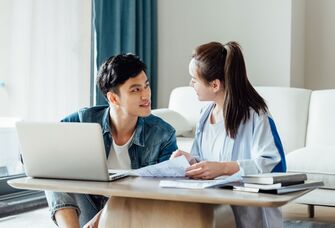 Young couple wedding planning on laptop at home