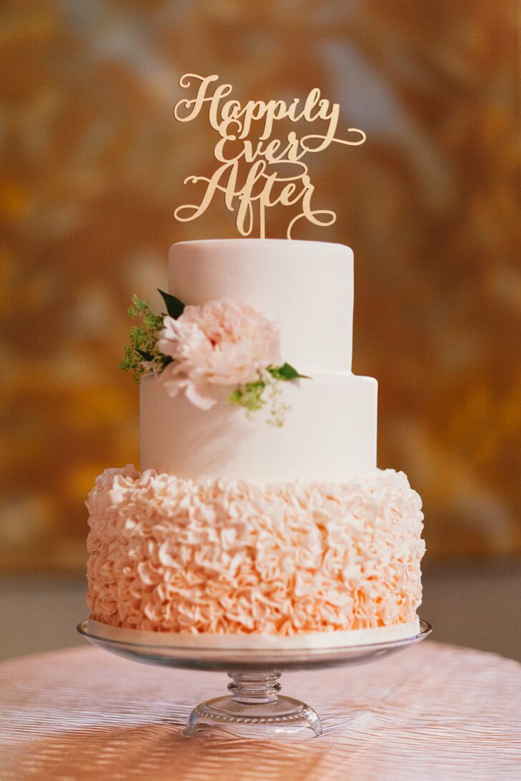 Katherine and Kevin ended dinner on a sweet note with a cake from Cake & Cookie Bakery. The blush pink confection featured three layers, the third of which was decorated with hundreds of small ombre ruffles. A single pink flower adorned the second tier and a whimsical Happily Ever After decoration from Better Off Wed was the finishing touch.