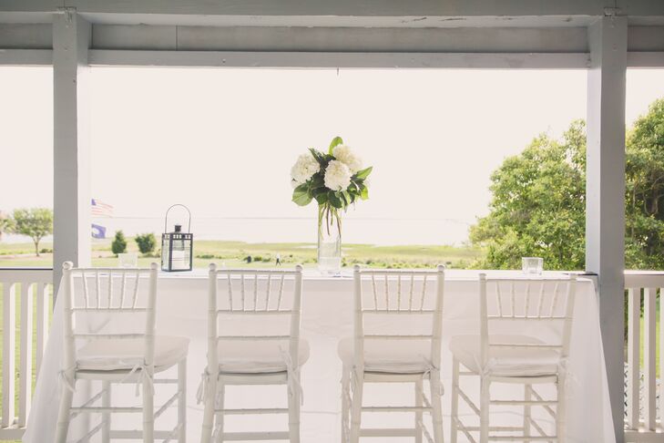 Alhambra Hall was the perfect location for Jenna and Joshua's lowcountry wedding because of its beautiful waterfront views. During cocktail hour, guests could enjoy these views on the patio, which was equipped with white cocktail tables and chiavari chairs. Flower arrangements of white hydrangeas and leafy greens decorated the outdoor area.