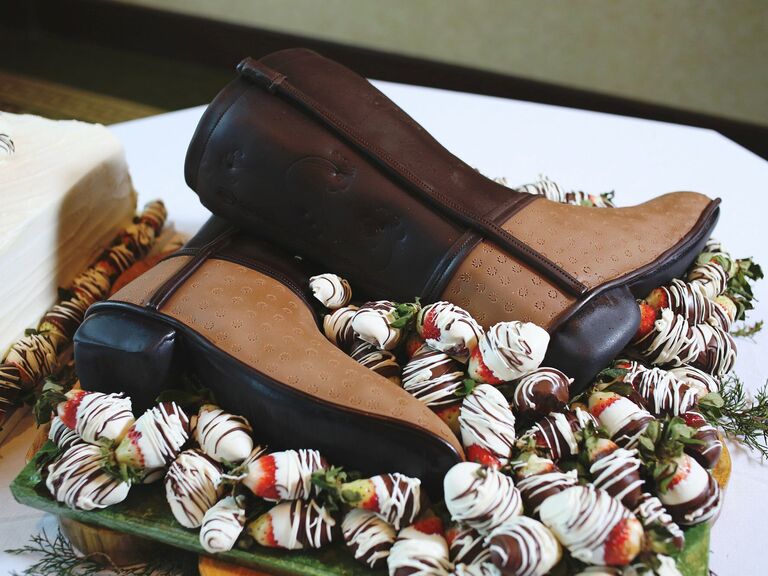 Cowboy boot-shaped Groom's cake featuring chocolate-covered strawberries. 