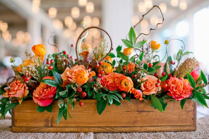 Tables were topped with arrangements of orange blooms and greenery that were displayed in rustic wooden boxes.