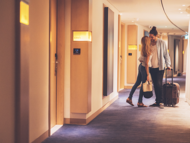 Couple stopping at the hotel corridor and kissing