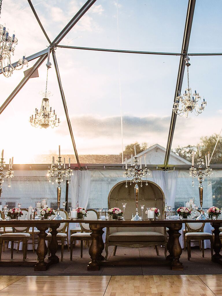 Chandeliers hanging over reception tables for a rustic wedding