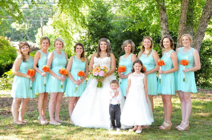 Since Candace knew exactly what color she wanted, the bridesmaid dresses were the first thing she picked out. She did tons of research online and ended up finding these short aqua dresses with illusion lace necklines and chiffon skirts at Francesca's, her favorite boutique. “I can always count on Francesca's to have what I need,” Candace says. Each woman changed up her look with a different hairstyle and her chosen neutral shoes. Bright DIY bouquets of orange daisies also helped tie it all together.