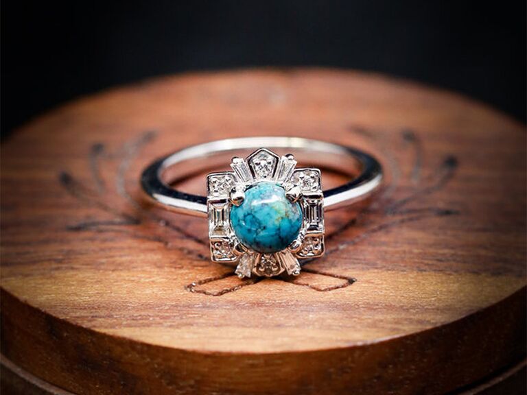 Uniquely shaped diamond halo bordering circle turquoise stone on silver band