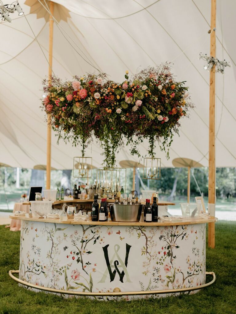 White floral and monogrammed wedding bar space in an outdoor reception