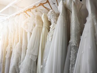 rack of beautiful wedding dresses on wooden hangers