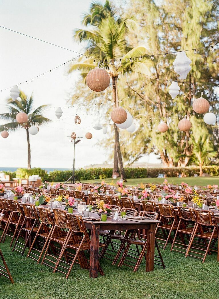Outdoor wedding reception with farm tables, folding bamboo chairs and woven chandeliers
