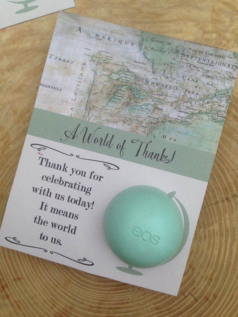 Top half in map design above 'A World of Thanks!' in loopy black script on light green stripe with EOS lip balm positioned as globe on bottom