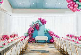 colorful hot pink and turquoise balloon backdrop at ballroom bridal shower