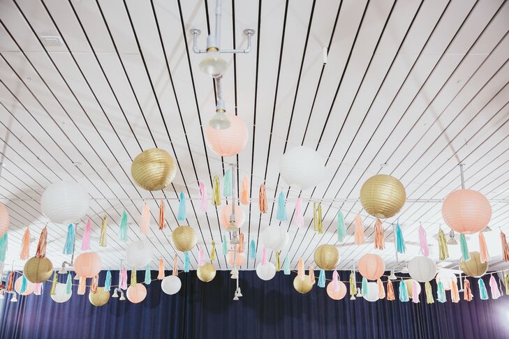 For the reception inside Ace Hotel & Swim Club in Palm Springs, California, paper lanterns and tassels decorated the white ceiling in colors of peach, gold, blue and white.