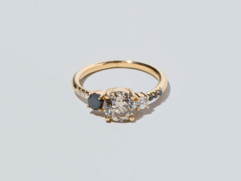 This Mociun engagement ring brings a sense of sophistication with a large white diamond complemented by a smaller black diamond.