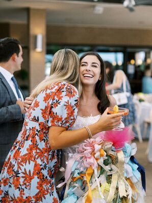 Bride Greeting Guest With a Cocktail at Her Italian-Themed Rehearsal Dinner