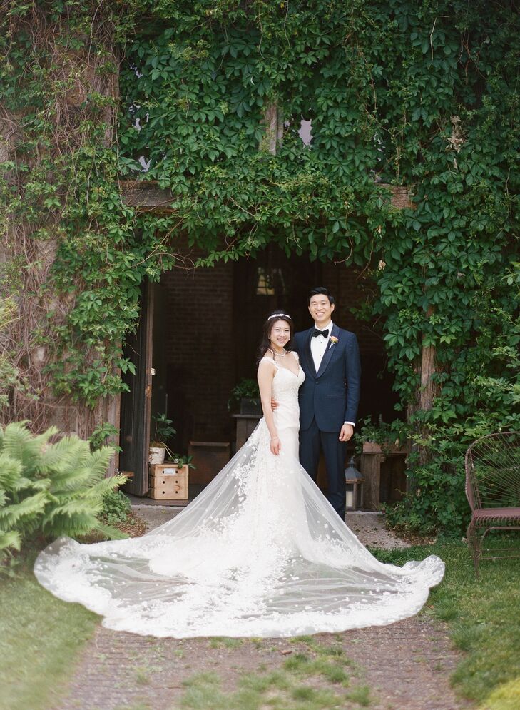 Following Taiwanese tradition, Alice donned several ensembles throughout the evening. For the ceremony, she opted for a glam mermaid-style gown with an embellished bodice and ethereal organza skirt with lace appliques. But the gown’s piece de resistance was the dramatic cathedral-length train that was decked out in shimmery embellishments and lace. She paired the look with a crystal headpiece, blusher veil and heirloom jewelry for a statement-making finish.