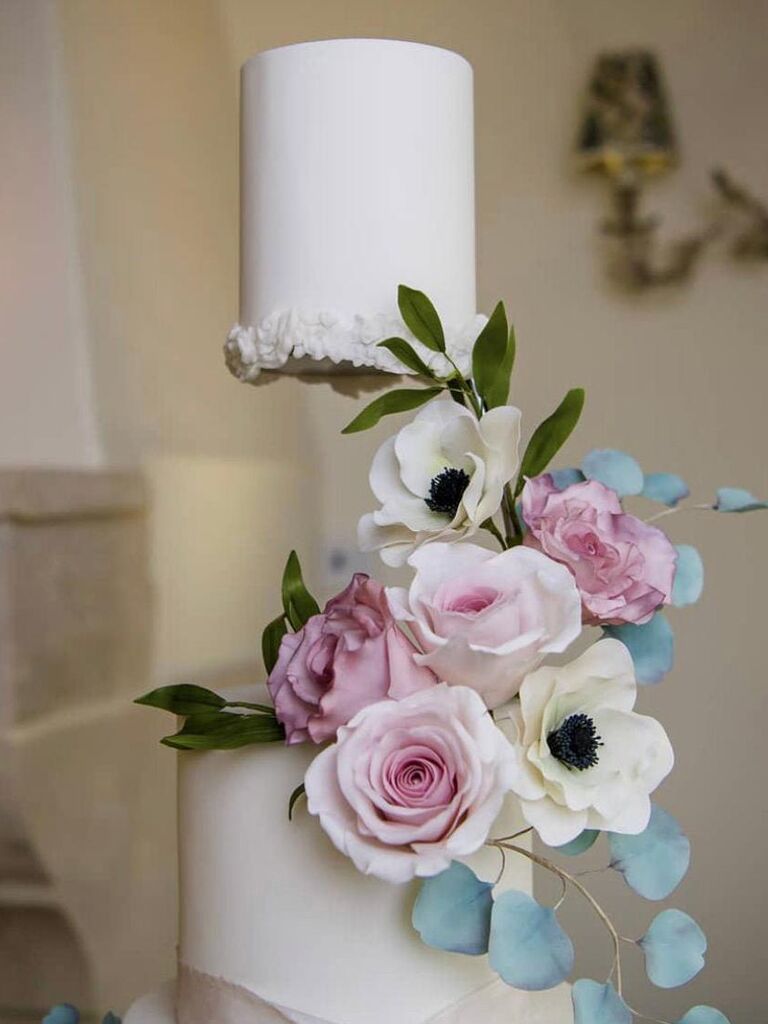 Close-up of floating top wedding cake tier with spacer hidden by flowers