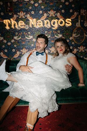 Bride and Groom Taking Photo at Custom Photo Backdrop Inspired by Wes Anderson Movies