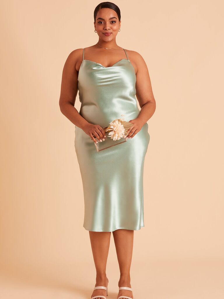 Model wears a mint green silk midi dress. 