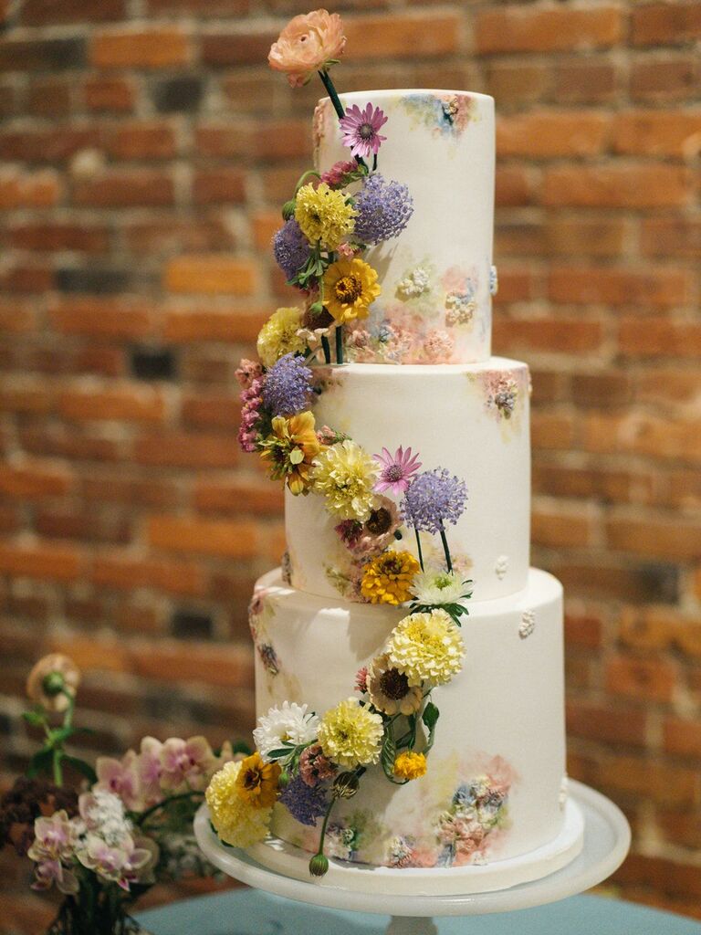 A 3-tier wedding cake with white buttercream and fresh flowers